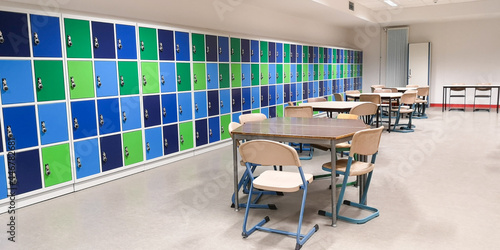 Empty junior high canteen,long wall closed colorful school lockers in gymnasium,other secondary educational institution,tables and chairs around in cafeteria,selective focus,copy space,back to concept