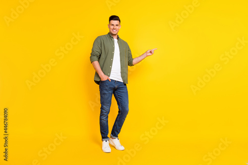 Full length body size photo guy pointing copyspace isolated vibrant yellow color background