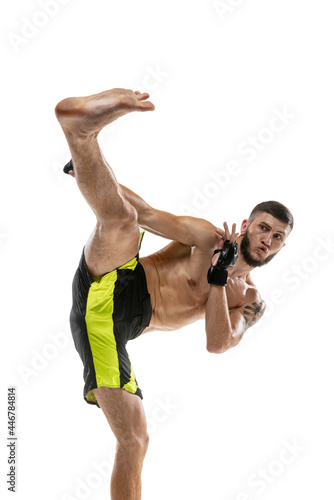 Professional male MMA boxer in motion isolated on white studio background. Fit muscular caucasian athlete fighting.