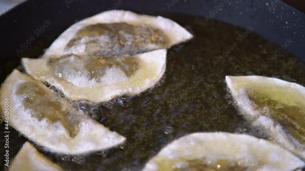 Gyoza dumplings with mushroom filling frying in hot pan. Golden crunchy dumplings cooking in oil. Gyoza dumplings with mushroom filling frying in hot pan. Golden crunchy dumplings cooking in oil.