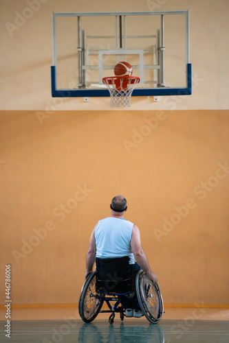 a war invalid in a wheelchair trains with a ball at a basketball club in training with professional sports equipment for the disabled. the concept of sport for people with disabilities © .shock