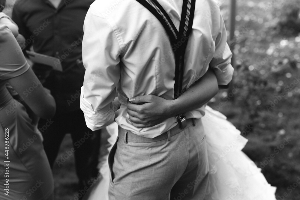 hugs of a young couple wedding dress suspenders black and white photo