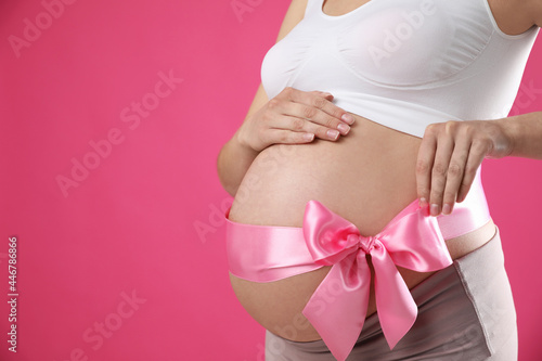 Wallpaper Mural Young pregnant woman with bow on her belly against pink background, closeup and space for text. Time to give birth Torontodigital.ca