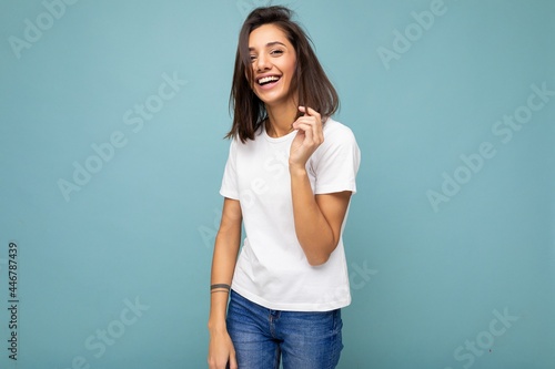 Photo of young positive happy smiling beautiful woman with sincere emotions wearing stylish clothes isolated over background with copy space © Ivan Traimak