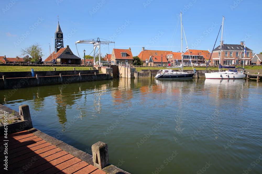 Naklejka premium The harbor of the historical town of Hindeloopen, Friesland, Netherlands, with historical houses, sailing boats and a drawbridge