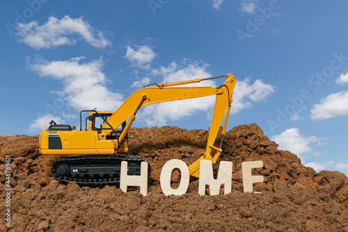 Home concept and Excavator digging the soil In the construction site area city on sky background