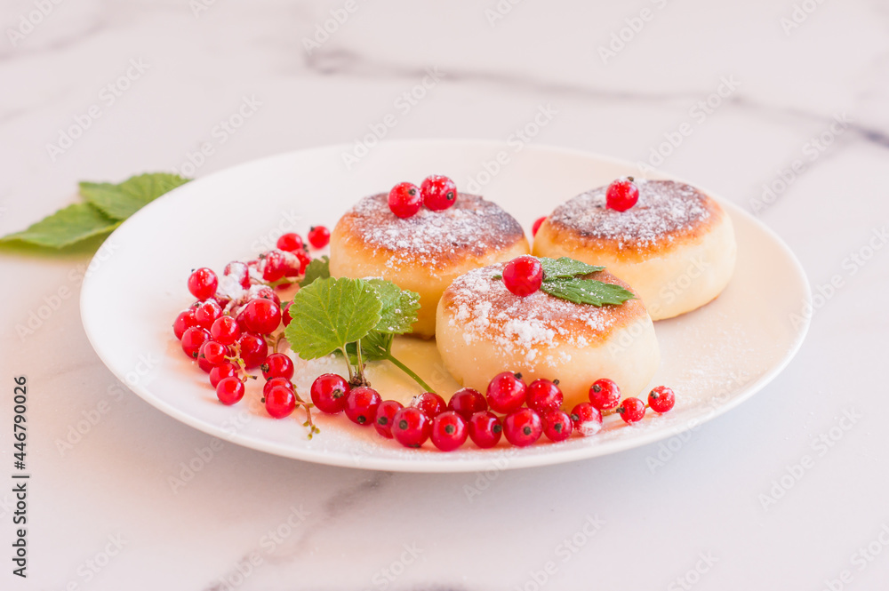 Cottage cheese pancakes, sweet curd fritters with red currant berries, syrniki on breakfast table