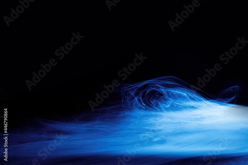 Art photo of blue smoke moves on black background. Beautiful swirling smoke.