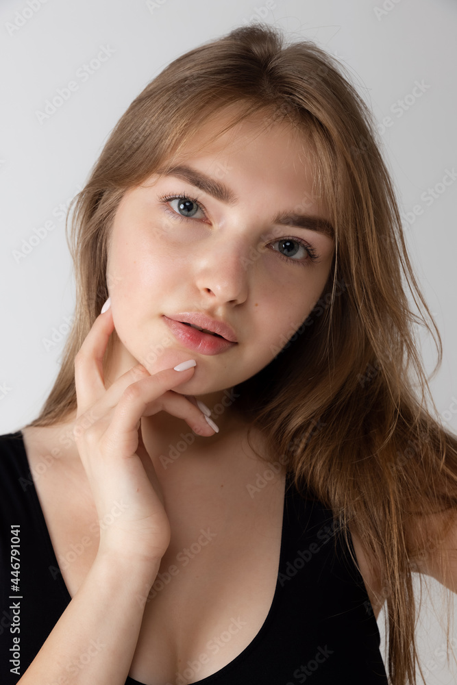 Close-up beautiful adorable young girl in black lingerie posing isolated over gray studio background. Natural beauty, spa, cosmetics and aesthetic cosmetology concept. Close-up beautiful adorable young girl in black lingerie posing isolated over gray studio background. Natural beauty, spa, cosmetics and aesthetic cosmetology concept.