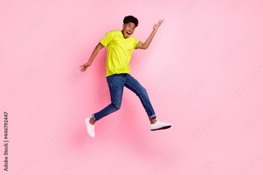 Full length profile side photo of young cheerful afro guy happy positive smile jump up isolated over pink color background