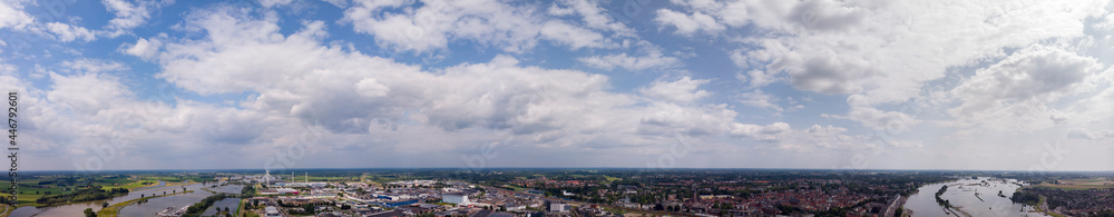 Horizon above Zutphen, The Netherlands, with cumulus clouds against a vibrant blue sky. Wide aerial weather condition panorama concept.