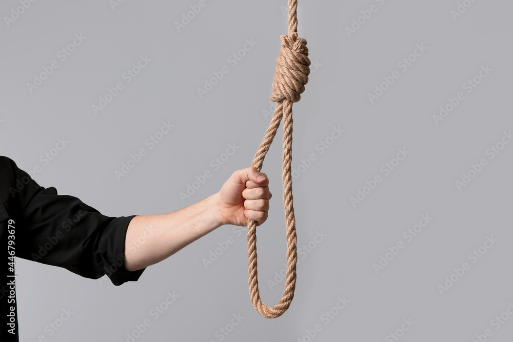 Man holding rope noose on light background, closeup Man holding rope noose on light background, closeup