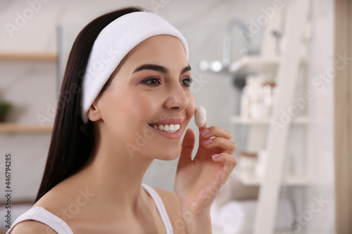 Woman using silkworm cocoon in skin care routine at home