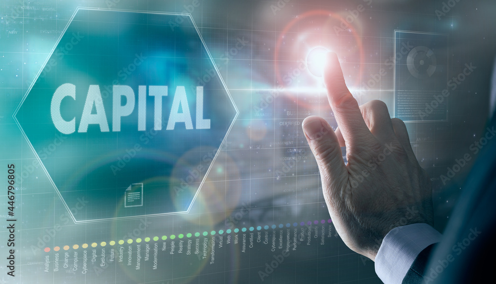 A businessman controlling a futuristic display with a Capital business concept on it. A businessman controlling a futuristic display with a Capital business concept on it.