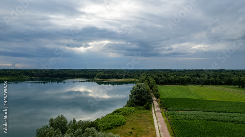 Aerial view of a beautiful and dramatic sunset over a forest lake reflected in the water  landscape drone shot. Blakheide  Beerse  Belgium. High quality photo