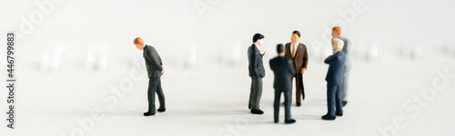 Miniature people A depressed Businessman mini figures standing out of group thinking on white background using as Success Business partnership development and Commerce Strategy Planning concepts