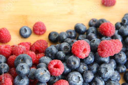 raspberries and blueberries on wooden table