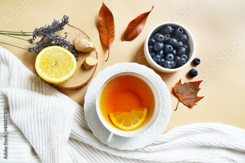 Lemon lavender tea and blueberries on the pastel beige background. Stay healthy in flu winter autumn days. Autumn fall tea composition. Calm cozy atmosphere. Soothing tea for a deep sleep and health.