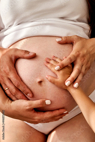 close up hands on mother and father making heart on pregnant big belly advanced pregnancy.