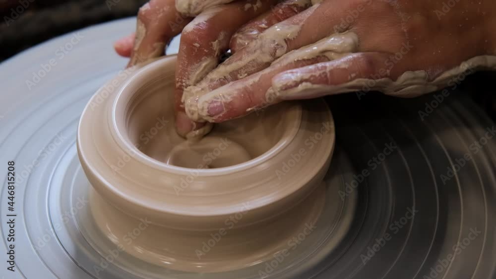Potter makes ceramic dishes on a twisted potter's wheel. Close-up of Potter at work. Handicraft, craft. White clay Potter makes ceramic dishes on a twisted potter's wheel. Close-up of Potter at work. Handicraft, craft. White clay