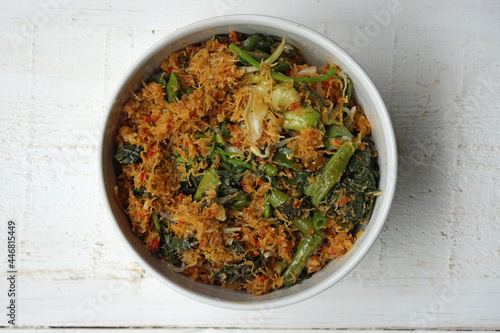 Indonesian salad made with boiled vegetables dressed with spiced grated coconut topping called Urap.                photo