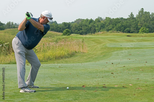 A golfer in mid-swing hitting from the fairway on a links course in Indiana.