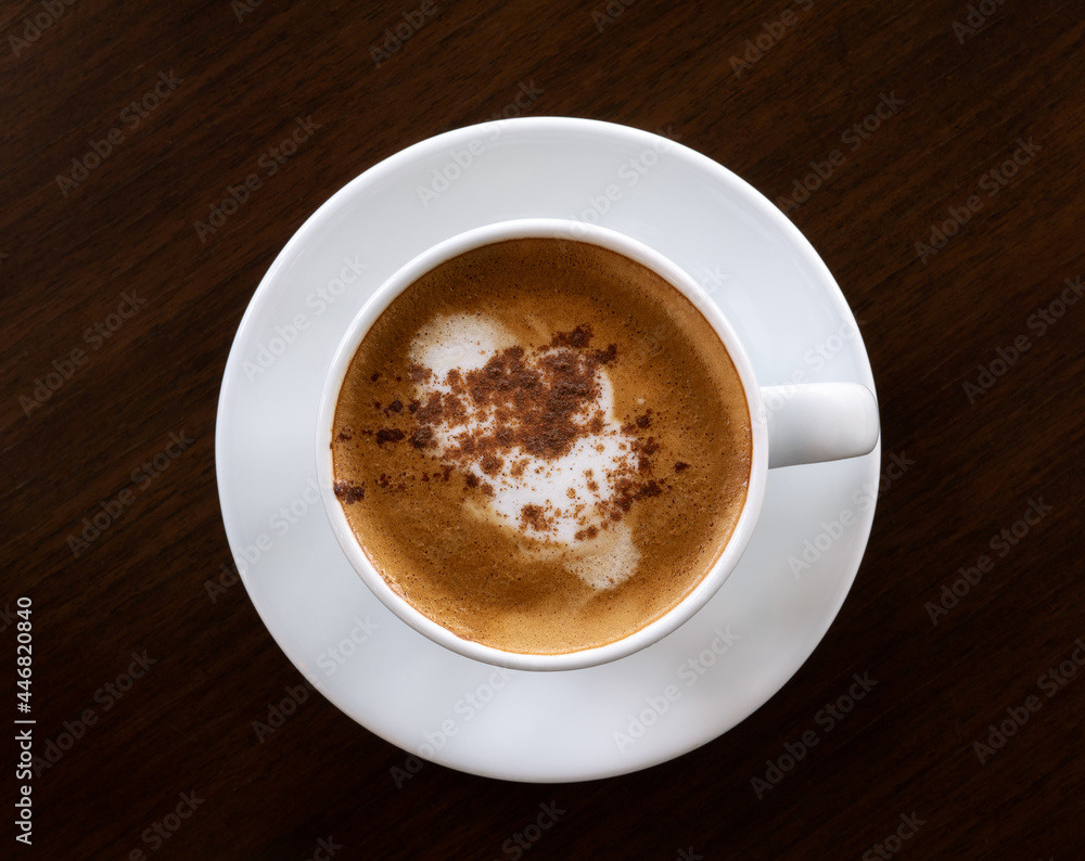 Top view hot coffee cappuccino latte in ceramic cup on dark wooden background Top view hot coffee cappuccino latte in ceramic cup on dark wooden background