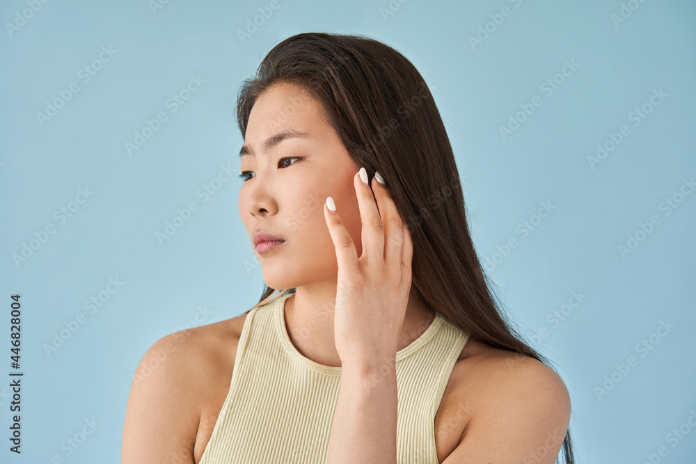 Woman with manicure looking away and touching her skin with her hand while posing Woman with manicure looking away and touching her skin with her hand while posing