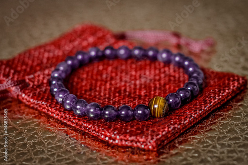 on the golden surface on a linen bag there is a bracelet made of natural stones