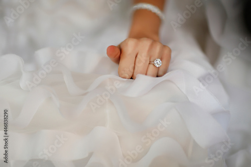 Bride s hand with beautiful diamond ring on white dress