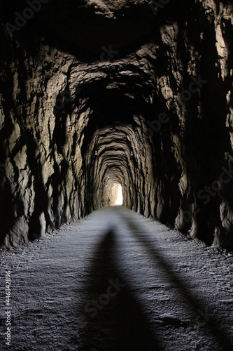 Dark stone tunnel to a cave with the dirt road to the Foz de Lumbier in Navarre