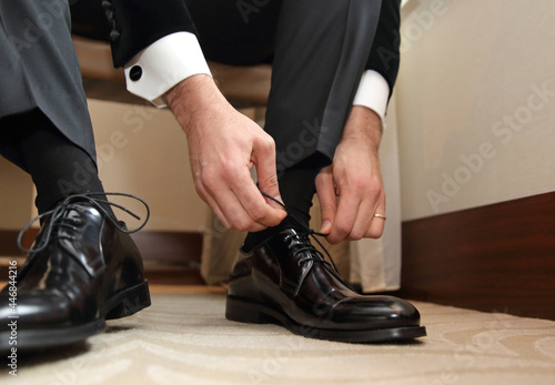 The man wears shoes. Prepare for work, to the meeting or wedding. Men's style.