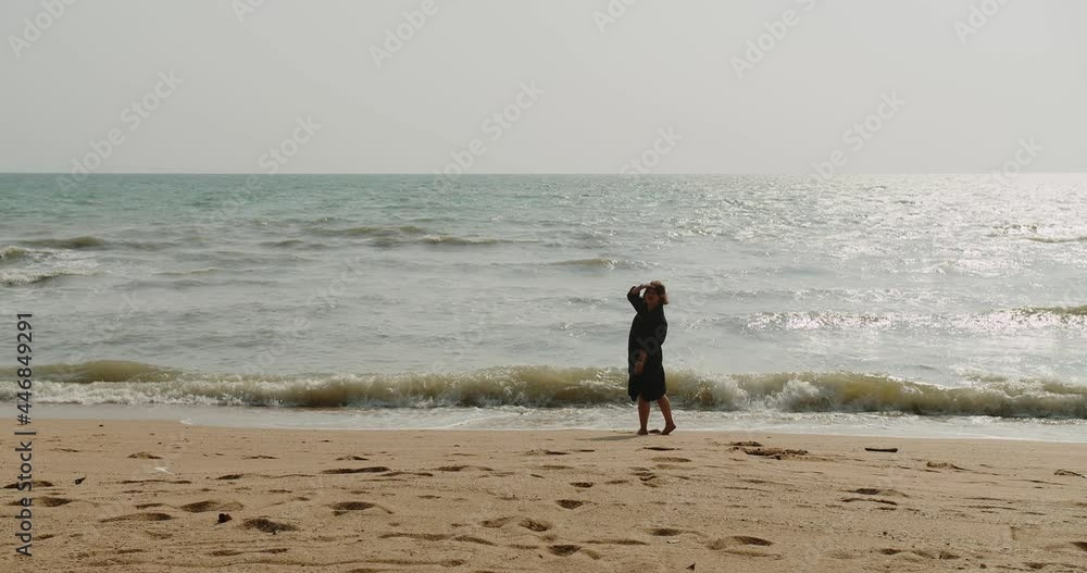 Attractive young woman standing enjoy vacation holiday on Tropical sand beach in afternoon sunny day with ocean surf sunlight background in summertime Attractive young woman standing enjoy vacation holiday on Tropical sand beach in afternoon sunny day with ocean surf sunlight background in summertime