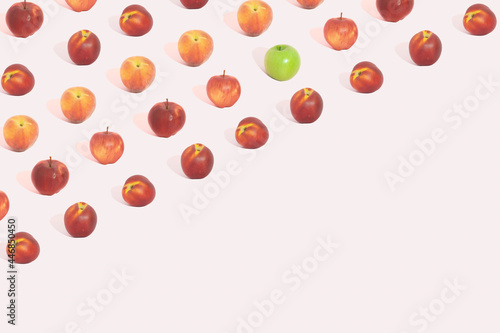 Different red fruit and one green apple  pattern on pastel pink background. Colorcolorful summer concept. Copy space. photo
