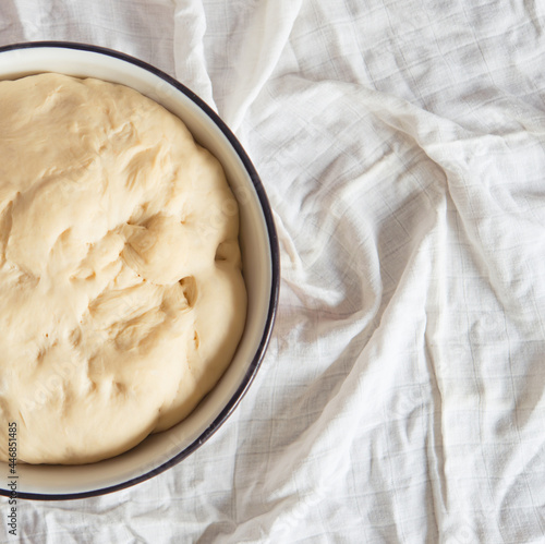 Process of raising the dough in a special basket. Dough made from natural sourdough. Wheat dough. Fermentation. Top view.	 photo