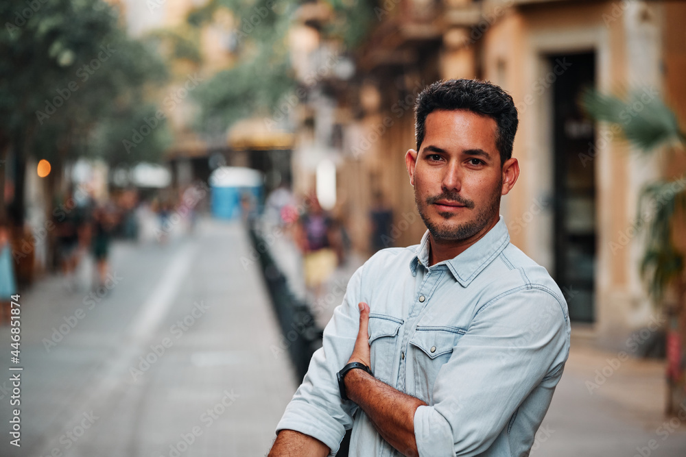 Portrait of a dark-haired Latin boy posing for a photo session on a street in the city of Barcelona.. Portrait of a dark-haired Latin boy posing for a photo session on a street in the city of Barcelona..