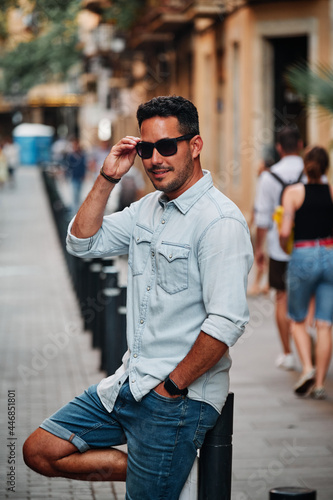 Portrait of a dark-haired Latin boy posing for a photo session on a street in the city of Barcelona..