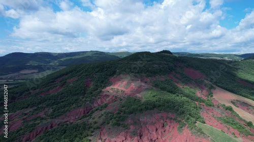 Rougier de Camarès en Aveyron en France. Montagnes et collines rouges d’Occitanie. Forêts, pâturages et champs. Villages de France.