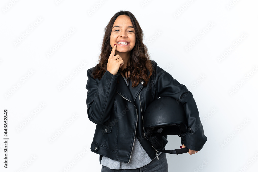 Young woman holding a motorcycle helmet over isolated white background smiling with a happy and pleasant expression Young woman holding a motorcycle helmet over isolated white background smiling with a happy and pleasant expression