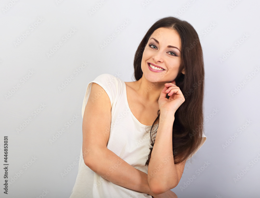 Beautiful young casual cute smiling woman on blue background looking up and thinking. Closeup portrait Beautiful young casual cute smiling woman on blue background looking up and thinking. Closeup portrait