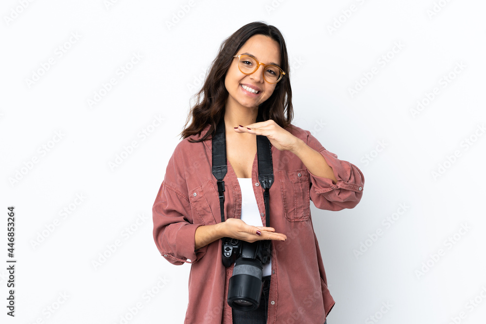 Young photographer woman over isolated white background holding copyspace imaginary on the palm to insert an ad Young photographer woman over isolated white background holding copyspace imaginary on the palm to insert an ad