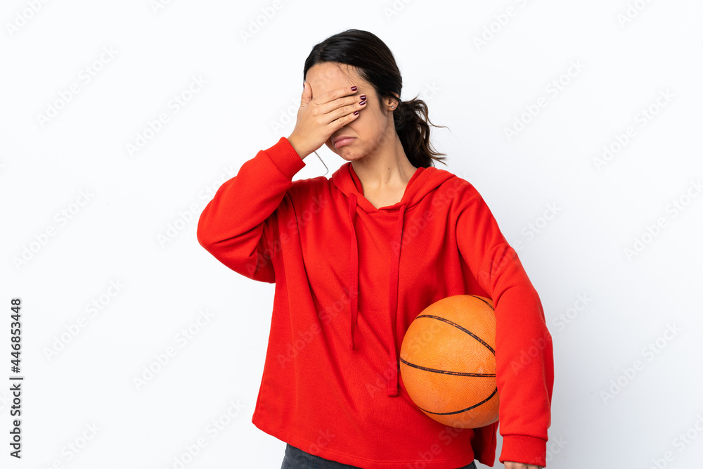 Young woman playing basketball over isolated white background making stop gesture and covering face