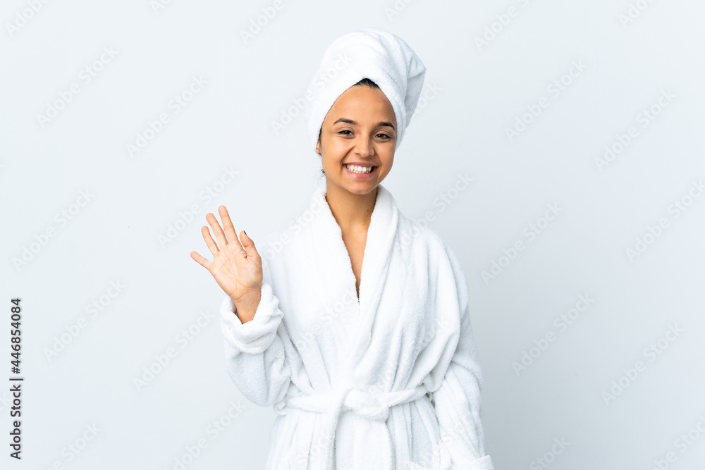 Young woman in bathrobe over isolated white background saluting with hand with happy expression Young woman in bathrobe over isolated white background saluting with hand with happy expression