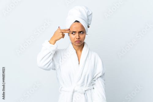 Young woman in bathrobe over isolated white background with problems making suicide gesture