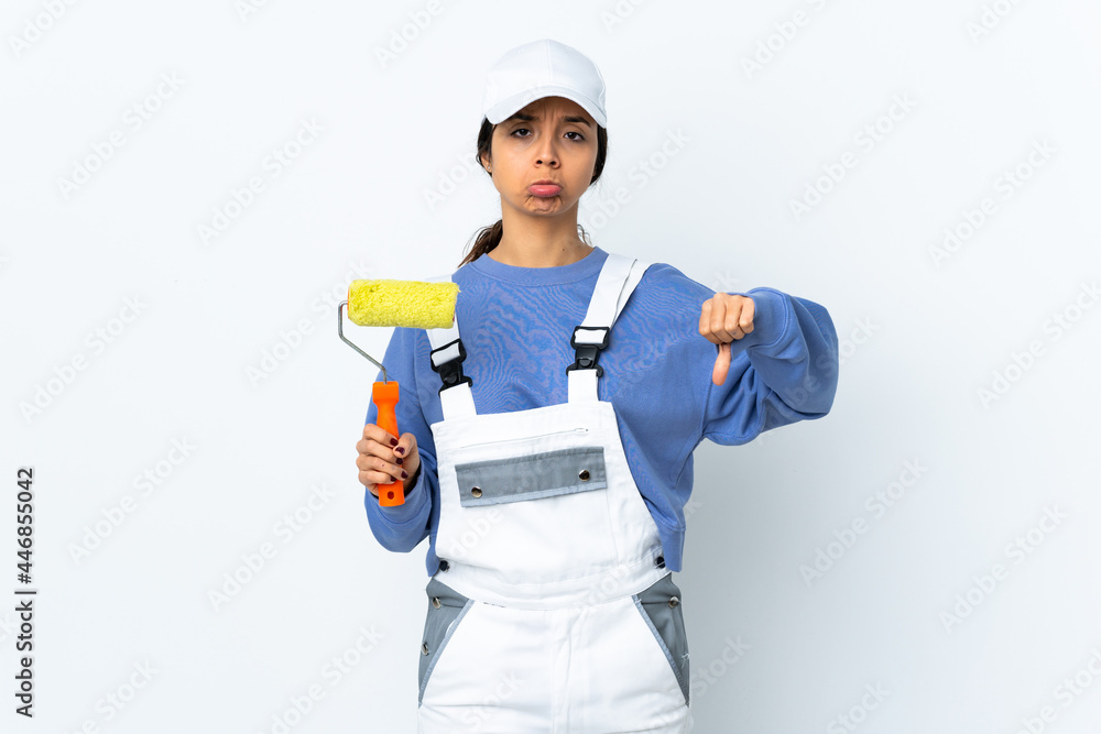 Painter woman over isolated white background making good-bad sign. Undecided between yes or not Painter woman over isolated white background making good-bad sign. Undecided between yes or not