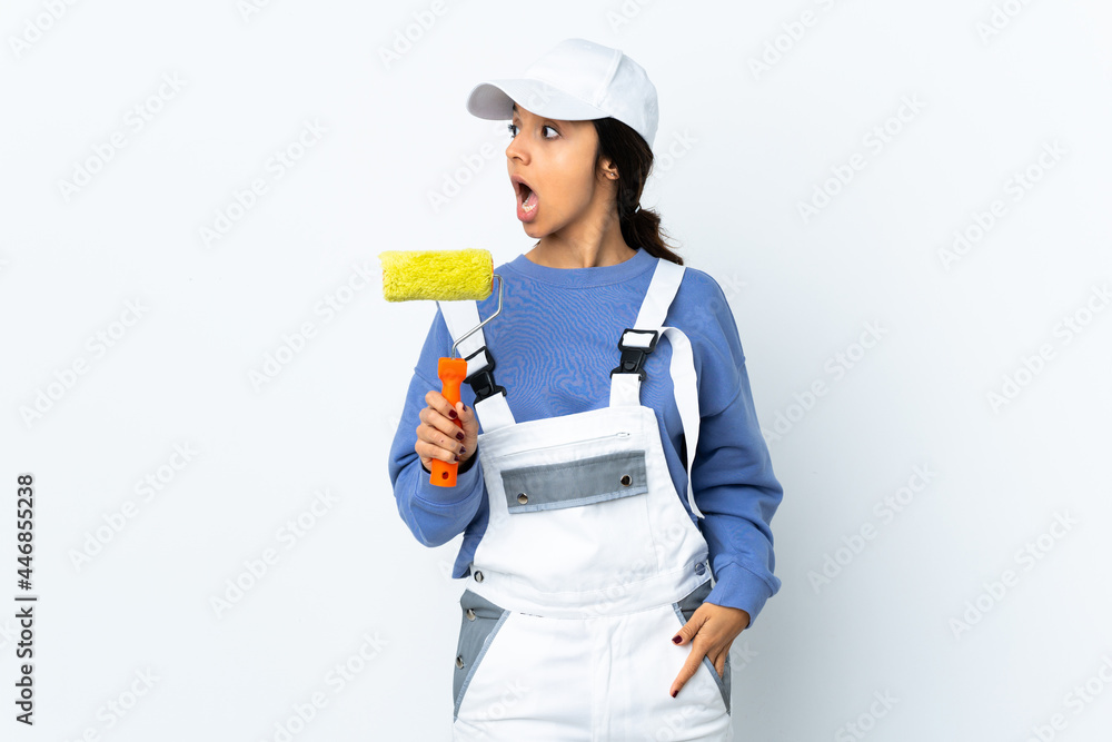 Painter woman over isolated white background doing surprise gesture while looking to the side Painter woman over isolated white background doing surprise gesture while looking to the side