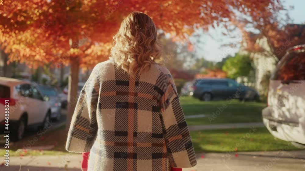 Woman walking by sideway, enjoying warm sunny autumn day. Back view of female 4K Woman walking by sideway, enjoying warm sunny autumn day. Back view of female 4K