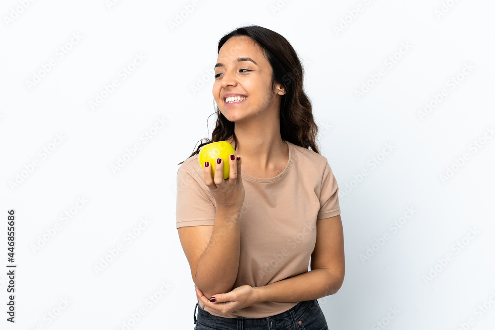 Young woman over isolated white background with an apple and happy Young woman over isolated white background with an apple and happy