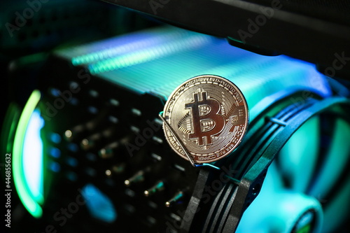 bitcoin coin is on computer hardware part with color backlight