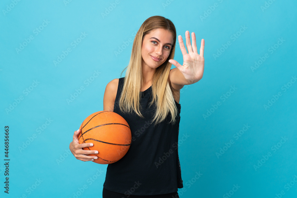 Young woman playing basketball isolated on white background counting five with fingers Young woman playing basketball isolated on white background counting five with fingers